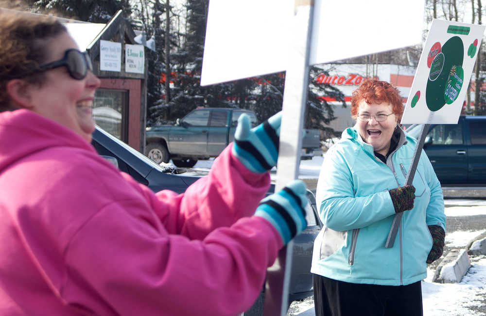 Photo by Rashah McChesney/Peninsula Clarion  Natalie Merrick, of Soldotna, and Susie Stafford, of Kenai, have a laugh after joking about running into traffic to deliver materials for the Green Dot Alaska campaign Tuesday April 8, 2014 in Soldotna, Alaska. The two were joined by others who stood at the intersection of the Kenai Spur Highway and the Sterling Highway offering information about the campaign to drivers who were interested. It is a violence prevention initiative funded through the Council on Domestic Violence and Sexual Assault and is currently being implemented in five Alaskan communities including Homer, Fairbanks, Juneau and Kenai.