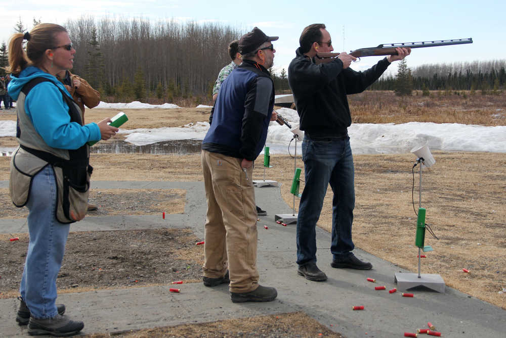 Photo by Dan Balmer/Peninsula Clarion Shawn Hutchings prepares to shoot as volunteer coach Stu Goldstein watches his form at a trap shooting clinic at the Snowshoe Gun Club on April 6. Alice Kerkvliet holds the controller to the clay target machine which releases a clay disc when the shooter yells "Pull."
