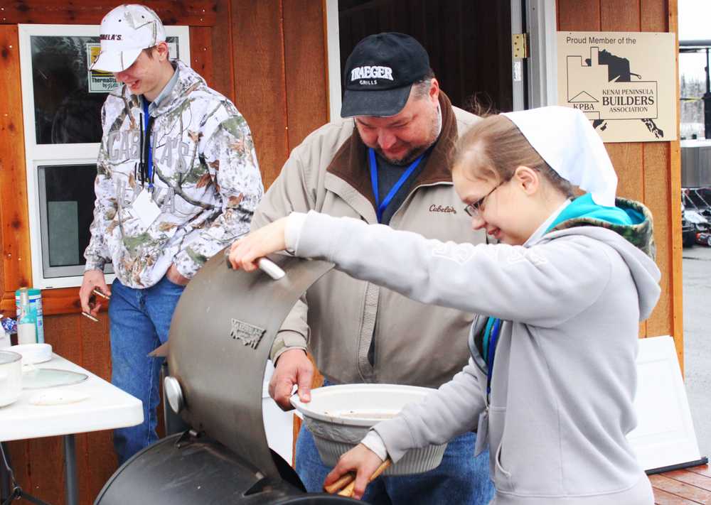 Photo by Kelly Sullivan/ Peninsula Clarion Marlin, Dale and Rita Eicher had two barbecues making steaming chicken to fend off the cold at the Kenai Peninsula Home Show, Saturday, April 12, at the Soldotna Sports Center. The Home Show continues today from 11 a.m.-5 p.m.