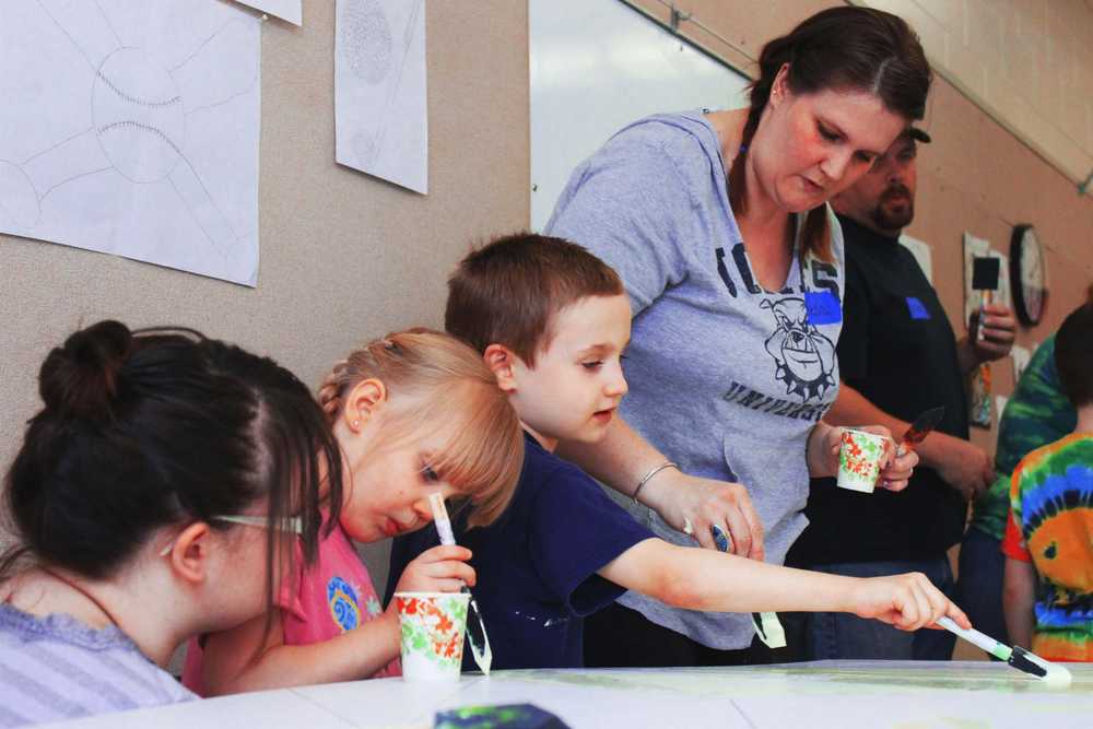 Photo by Kelly Sullivan/ Peninsula Clarion Elizabether, Bella, Noah and Kecia Hunter (left to right), came as a family to work on the Nikiski community mural, Friday and Saturday, April 11 and 12, at the Nikiski Recreation Center.