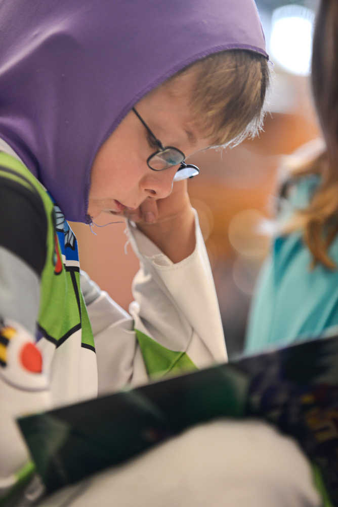 Photo by Rashah McChesney/Peninsula Clarion  First-grader Dane Focose reads along with Barbara Ralston's class dressed as the Toy Story character Buzz Lightyear Wednesday April 16, 2014 in Kenai, Alaska. Students at Mountain View Elementary School dressed up as characters for the day.