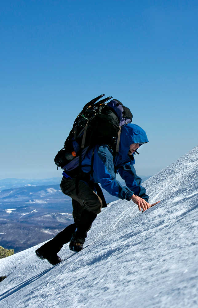 In this Friday, April 4, 2014 photo, Joe Murdzek scrambles up a snowfield while climbing Mount Adams in the Northern Presidential Range of the White Mountains in New Hampshire. Murdzek, 47, of East Hartford, Conn, and three high school friends have made a tradition of getting away on overnight climbing trips as a way to "hit the reset button" from the daily grind. (AP Photo/Robert F. Bukaty)