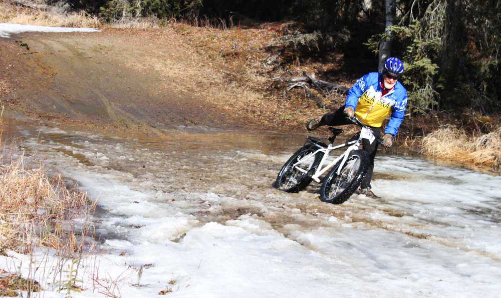 Photo by Kelly Sullivan/ Peninsula Clarion Many cyclists had to get off and walk their "weapons" through the muddy pools of melting ice on Wolverine trail, Saturday, April 19, at the Tsalteshi Trail.