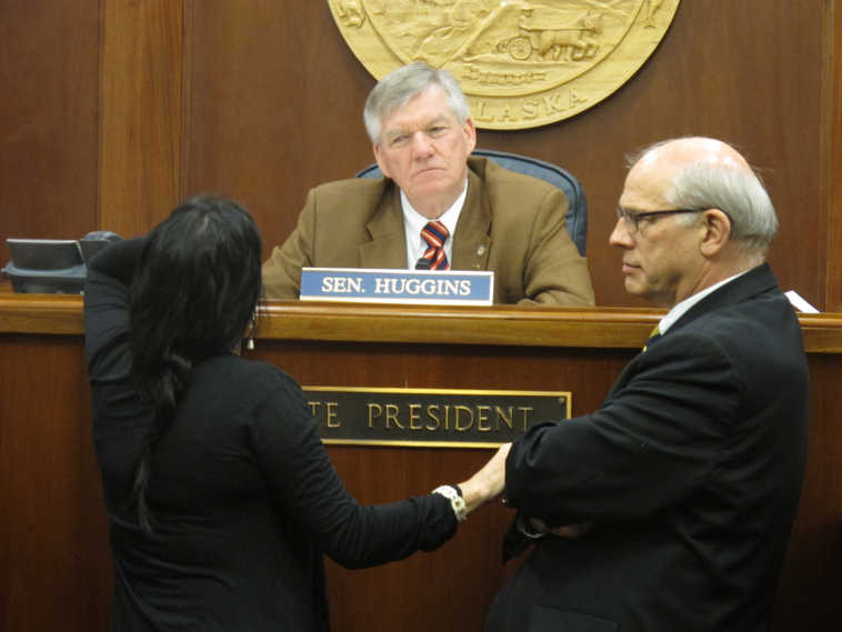 Sens. Lesil McGuire, left, and John Coghill, the majority leader, speak with Senate President Charlie Huggins during a break in floor debate on an education bill on Monday, April 21, 2014, in Juneau, Alaska. (AP Photo/Becky Bohrer)