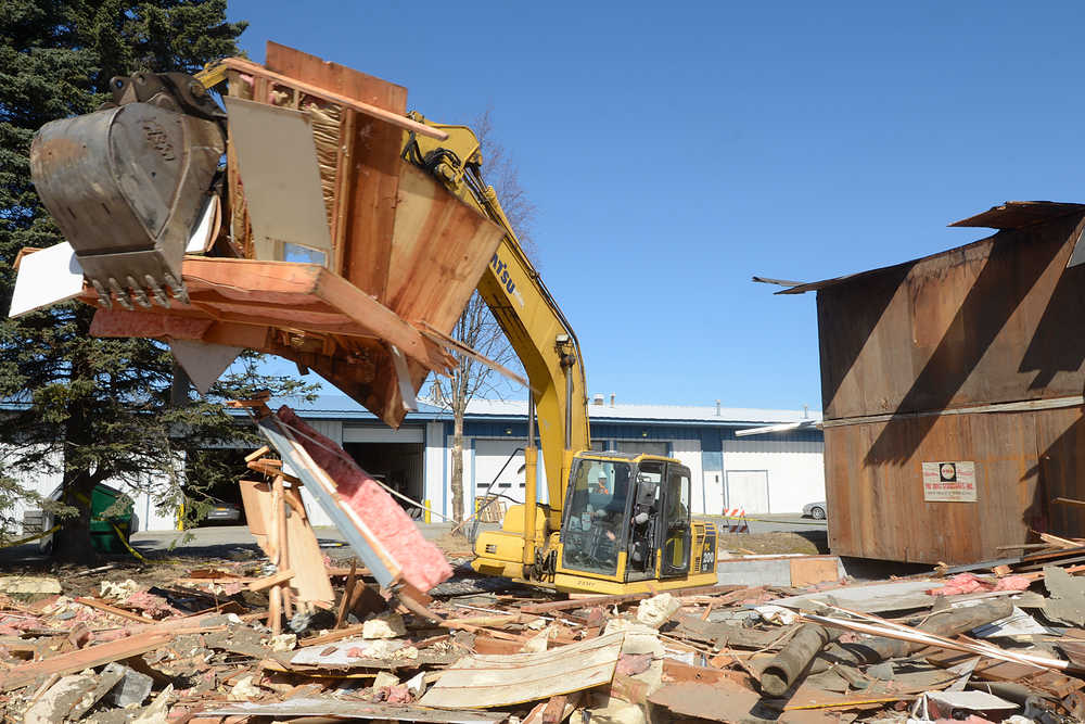 Photo by Rashah McChesney/Peninsula Clarion  Rex Bircham, of Triangle Recycling, uses an excavator to tear down a portion of the Merit Inn Tuesday April 22, 2014 in Kenai, Alaska. The former hotel was operated as the Family Hope Center, a transitional housing facility, until June 2013 when the organization could no longer afford the facility.