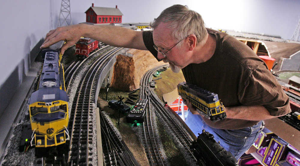 In this photo taken on Tuesday afternoon, April 15, 2014, Richard Oehrig swaps locomotives on the upper rail line of his model railroad he's building in a friend's warehouse in Fairbanks, Alaska. Oehrig spends his lunch hours laying railroad track and carefully gluing pieces of scale-size gravel along the tracks. Sometime he's so busy with his project that he doesn't eat.(AP Photo/Fairbanks Daily News-Miner, Eric Engman) MAGS OUT, NO SALES