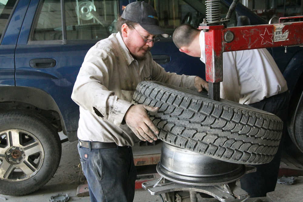 Photo by Dan Balmer/Peninsula Clarion Donald Pootjes removes a studded tire from its rim at Alyeska Tire in Kenai Monday. Thursday is the deadline to have studded tires removed from vehicles traveling on central Kenai Peninsula roads.