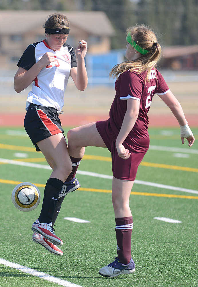 Photo by Rashah McChesney/Peninsula Clarion  Kenai's Lara Creighton takes a kick from Grace Christian's Laura Aspelund during their game Saturday May 3, 2014 at Kenai Central High School in Kenai, Alaska.