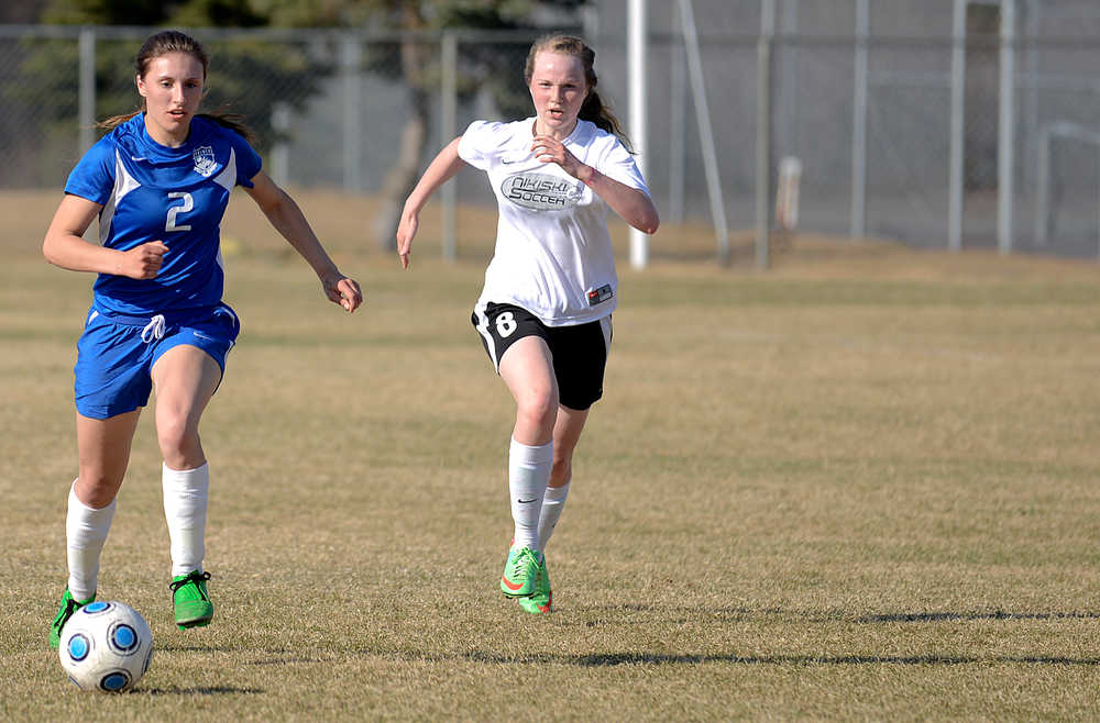 Photo by Rashah McChesney/Peninsula Clarion  Palmer's Carly Venzke gets away from Nikiski's Chloe Braun Friday May 2, 2014 during their game in Nikiski.