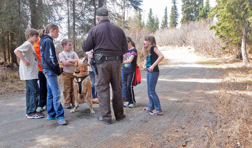 Photo by Rashah McChesney/Peninsula Clarion  United States Fish and Wildlife Service's Rob Barto tells a group of students at a Youth Game Warden camp about his yellow lab Rex and how Rex is used to find evidence of paching and illegal trafficking of wildlife Saturday May 3, 2014 at the Kenai National Wildlife Refuge headquarters in Soldotna, Alaska.
