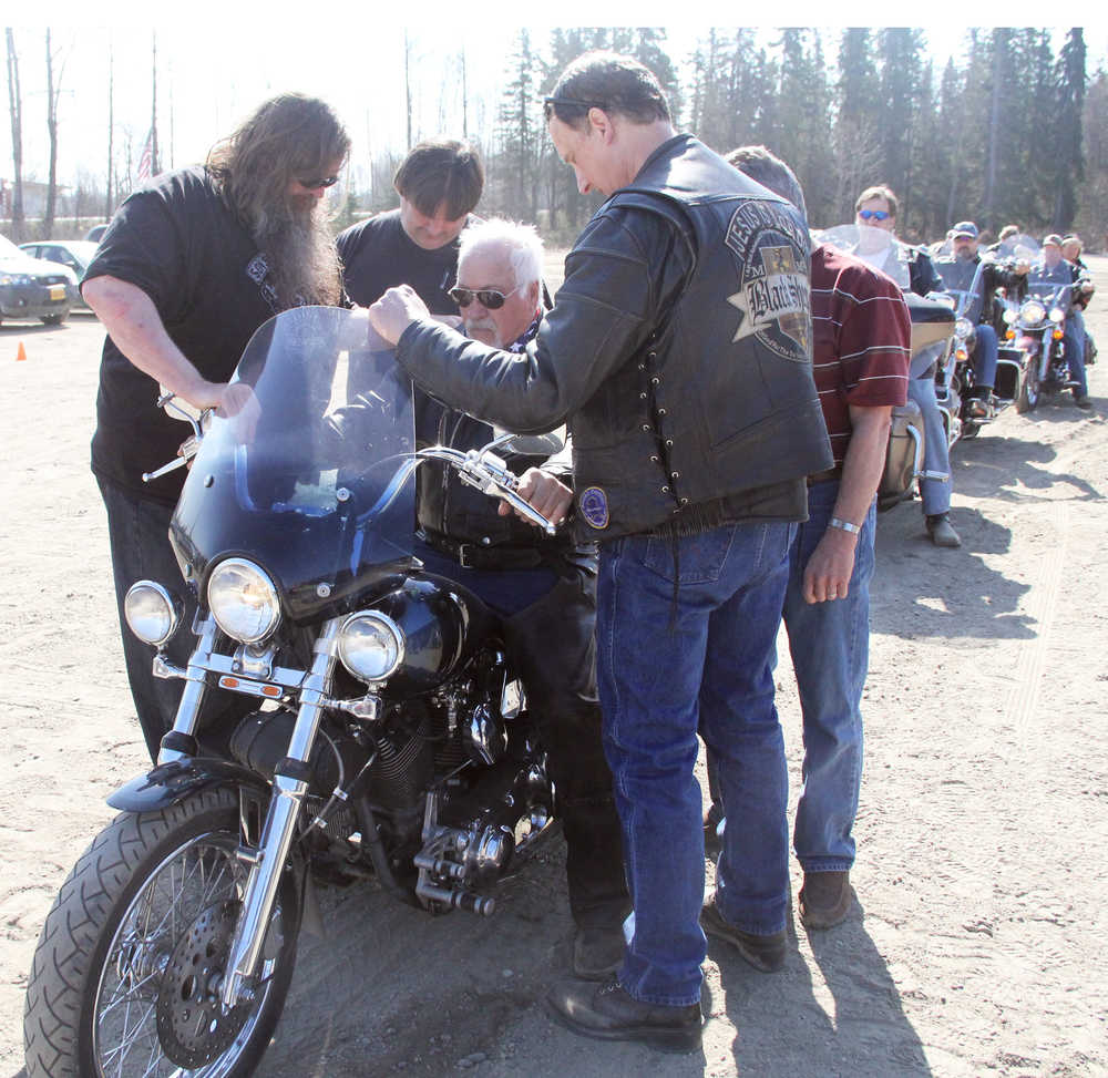 Photo by Dan Balmer/Peninsula Clarion Antonio "Chico" Sandoval receives a prayer from Scott Hammon (left) and Gary Anderson (right) for safe riding on his 2002 Santee motorcycle at the Biker Blessing at the Church of the Nazarene in Nikiski Sunday. More than 40 bikers from all over the Kenai Peninsula attended the blessing.