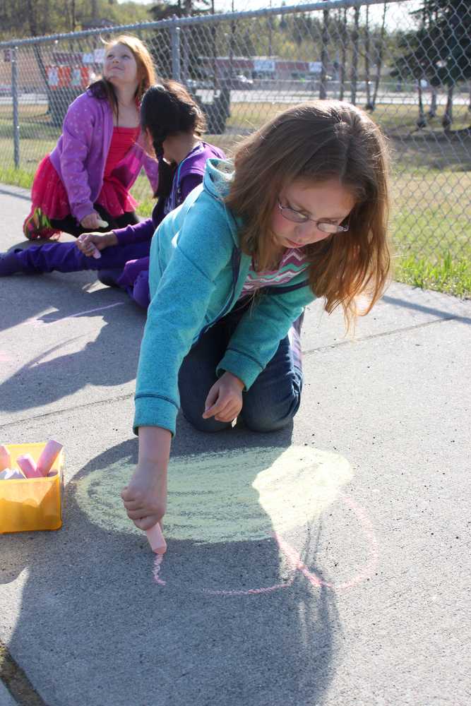 Photo by Kelly Sullivan/ Peninsula Clarion Trinity Murphy and her classmates in Shaya Straw's third grade Soldotna Middle School Elementary drew on the sidewalk while waiting for their turn to go a tour, Thursday, May 8, at the Soldotna Historic Post Office.