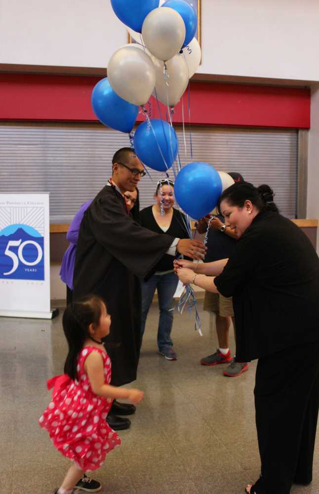 Photo by Kelly Sullivan/ Peninsula Clarion  Jimmy Andrews grabs some decorations for his daughter Janeva Andrews, Thursday, May 8, at the Kenai Peninsula College graduation reception.