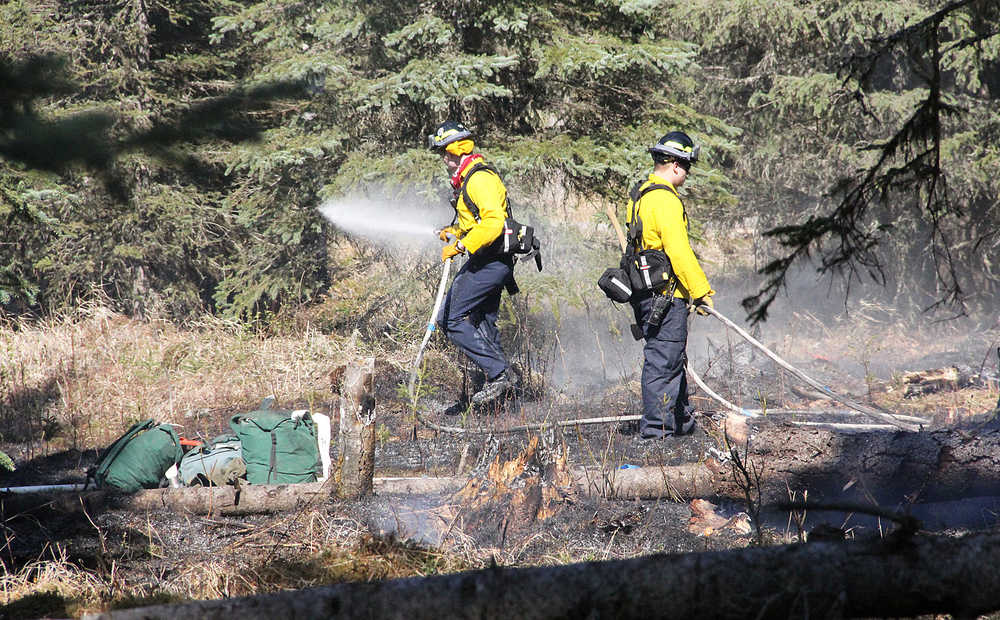 Photo by Dan Balmer/Peninsula Clarion Fire crews put out a grass fire in the backyard of a residence on Franke Road off of Poppy Ridge in Soldotna Sunday. Central Emergency Services received the call at about 4:30 p.m. and along with assistence from the Division of Forestry, the small fire was contained. Crews cleared the scene after one hour. The owner of the residence declined to comment. CES health and safety officer Brad Nelson said the family was having a bonfire and the fire spread to the grass.