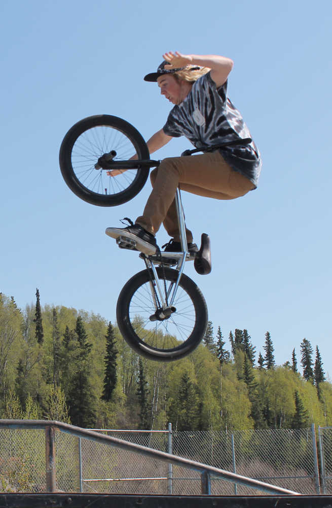 Photo by Will Morrow/Peninsula Clarion Oliver Larrow laughs as he climbs back onto his bike after not quite landing a stunt at the Karen Street skate and BMX park in Soldotna Monday.
