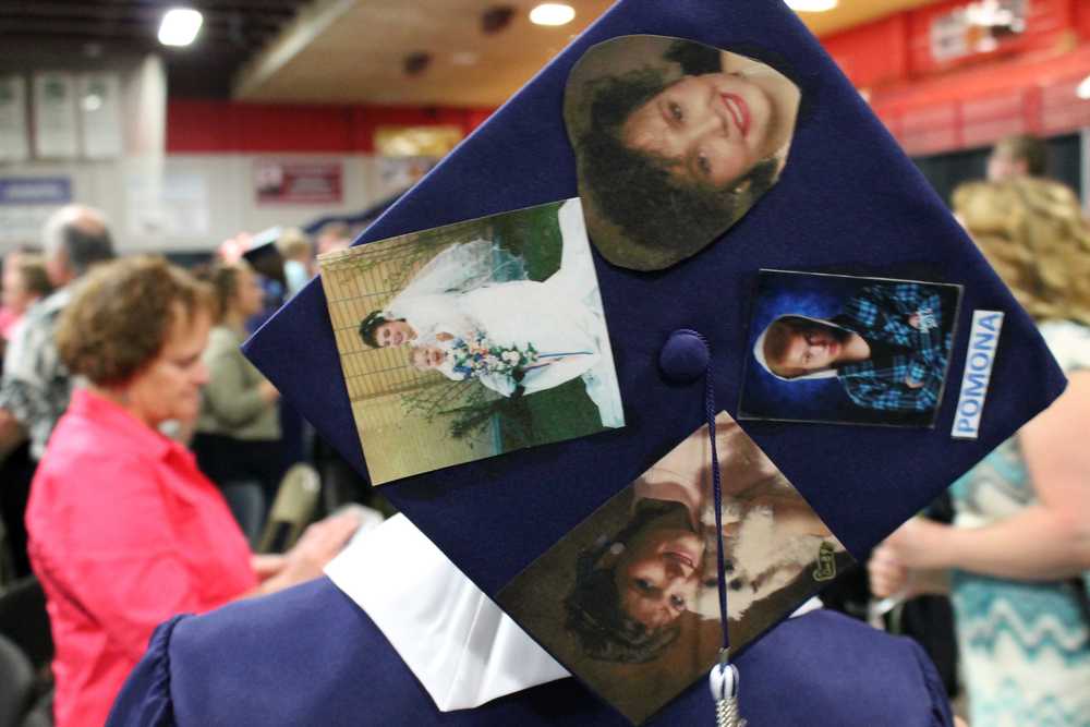 Photo by Dan Balmer/Peninsula Clarion Soldotna High graduate Malyq McElroy shows pictures of his mother he put on the back of his cap at his graduation at the Regional Sports Complex Monday. His mother passed away when he was nine and his grandmother has raised him since.