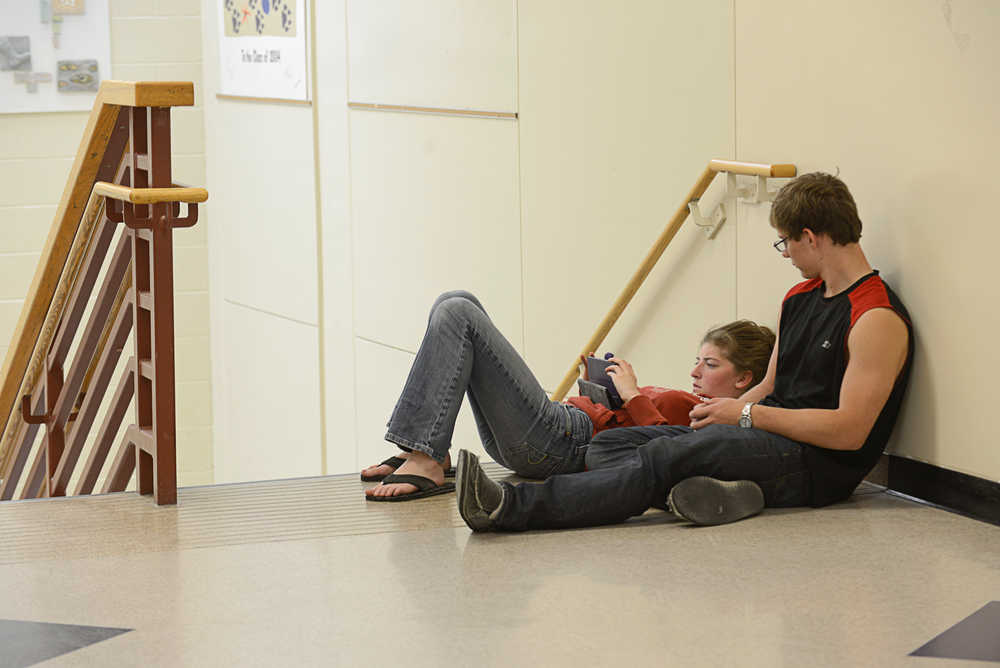 Photo by Rashah McChesney/Peninsula Clarion  Jasmyn Foost and Austin Schrader, both freshman, sit by a stairwell on the last day of school Wednesday May 21, 2014 at Skyview High School in Soldotna, Alaska.