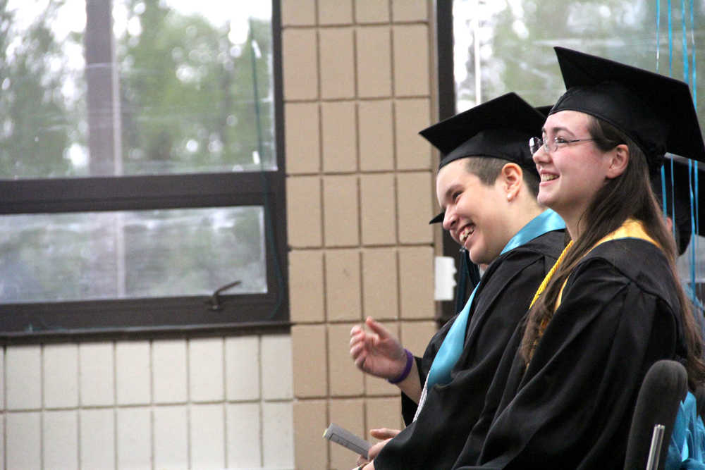 River City Academy graduates Kiowa Richardson (forward) and Shelby Fletcher (back) laugh as Principal Dawn Edwards-Smith talks about the class at the school's graduation ceremony on Wednesday at the Soldotna Regional Sports Complex. Kaylee Osowski/Peninsula Clarion