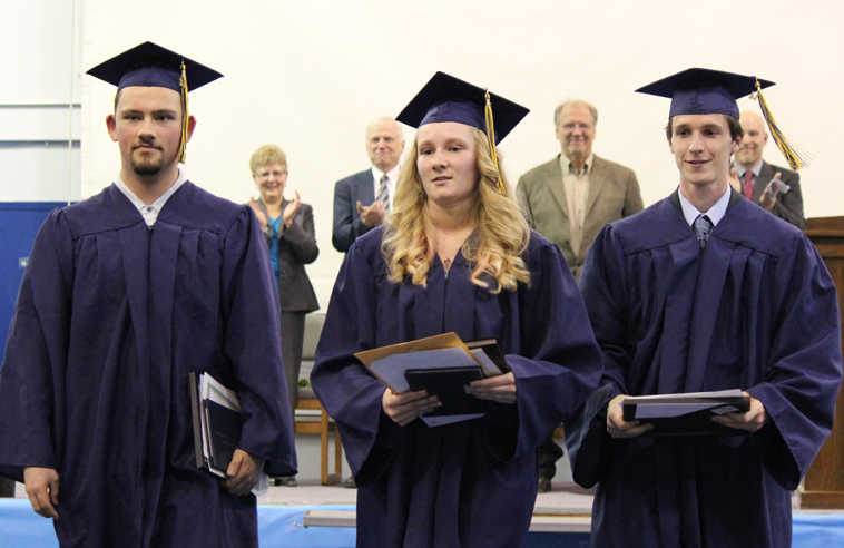 Ninilchik high school class of 2014 - Robert Delgado, Jessica Rogers and Matthew Thorne -  leave the May 21 commencement ceremonies, applauded by Ladawn Druce, school counselor; Jim White, director of the Kenai Peninsula Borough School District's information services department;  Joe Arness, KPBSD School Board president; and Jeff Ambrosier, principal of NInilchik School.
