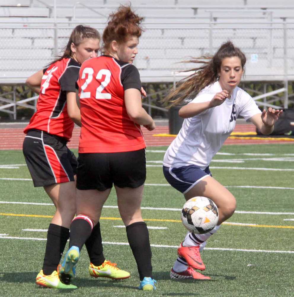 Soldotna's Reagan Schoessler tries to move the ball around Kenai's Sarah Every (24) and Caitlin Steinbeck (22) during a 5-0 win over the Kards.