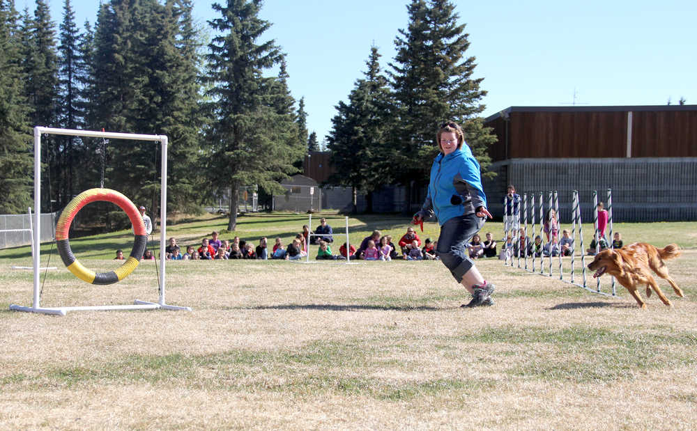 Katie Moon takes her dog, Lucy, through an agility course Tuesday, May 20, as students from Kalifornsky Beach Elementary School in Soldotna watch. Photo by Kaylee Osowski/PeninsulaClarion