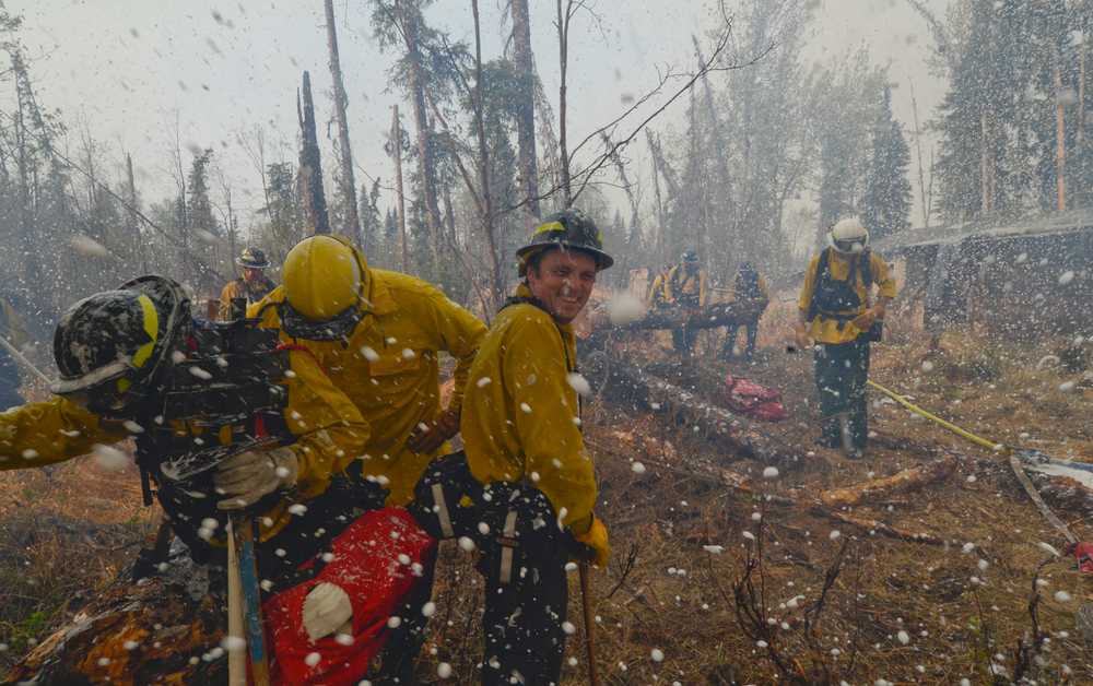 AP Photo/Peninsula Clarion, Rashah McChesney  Central Emergency Services firefighter Terry Bookey laughs as his crew are showered with foam while fighting the Funny River Horse Trail wildfire Sunday May 25, 2014 in the Funny River community in Soldotna, Alaska. Several firefighting crews have been working to keep the 156,041 acre wildfire from encroaching into the more than 1,000 homes  in Funny River which was evacuated Sunday afternoon.