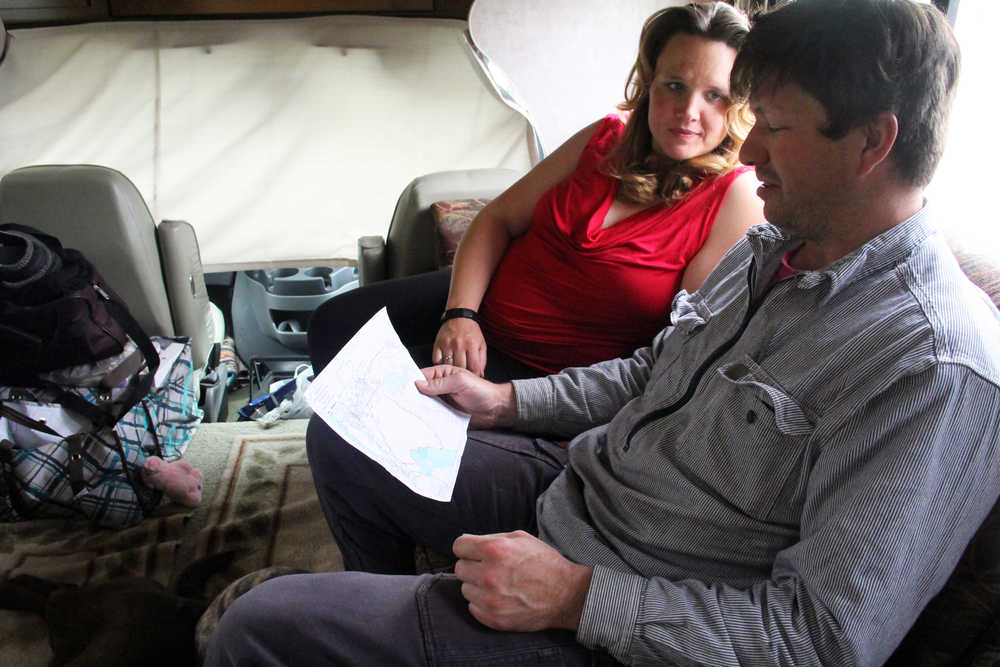 Photo by Dan Balmer/Peninsula Clarion Leticia and Joe Thiede look at a recent map of the wildfire that forced them to evacuate their home on Funny River Road Sunday. Leticia, who is eight months pregnant with their first child, said the ordeal has been stressful. The family stayed the past two nights at an RV Park until the evacuation was lifted Tuesday.