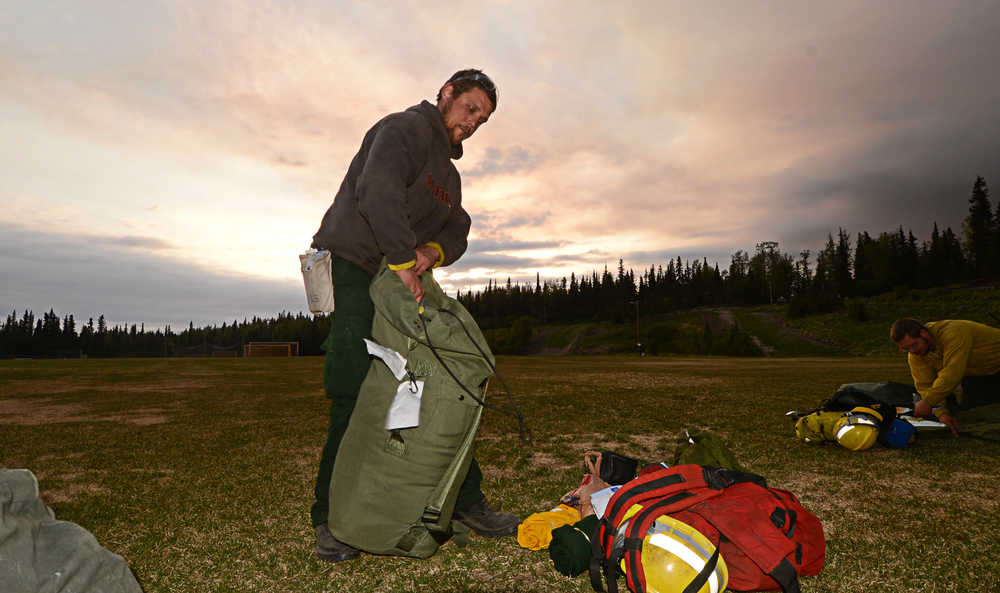 Photo by Rashah McChesney/Peninsula Clarion  Timofey Kolosov, firefighter from Delta Junction, sets up a tent in the Skyview High School soccer field Monday May 26, 2014 in Soldotna, Alaska. Kolosov and his crew arrived to help fight the Funny River Horse Trail wildfire which has burned more than 176,000 acres of Kenai National Wildlife Refuge land.