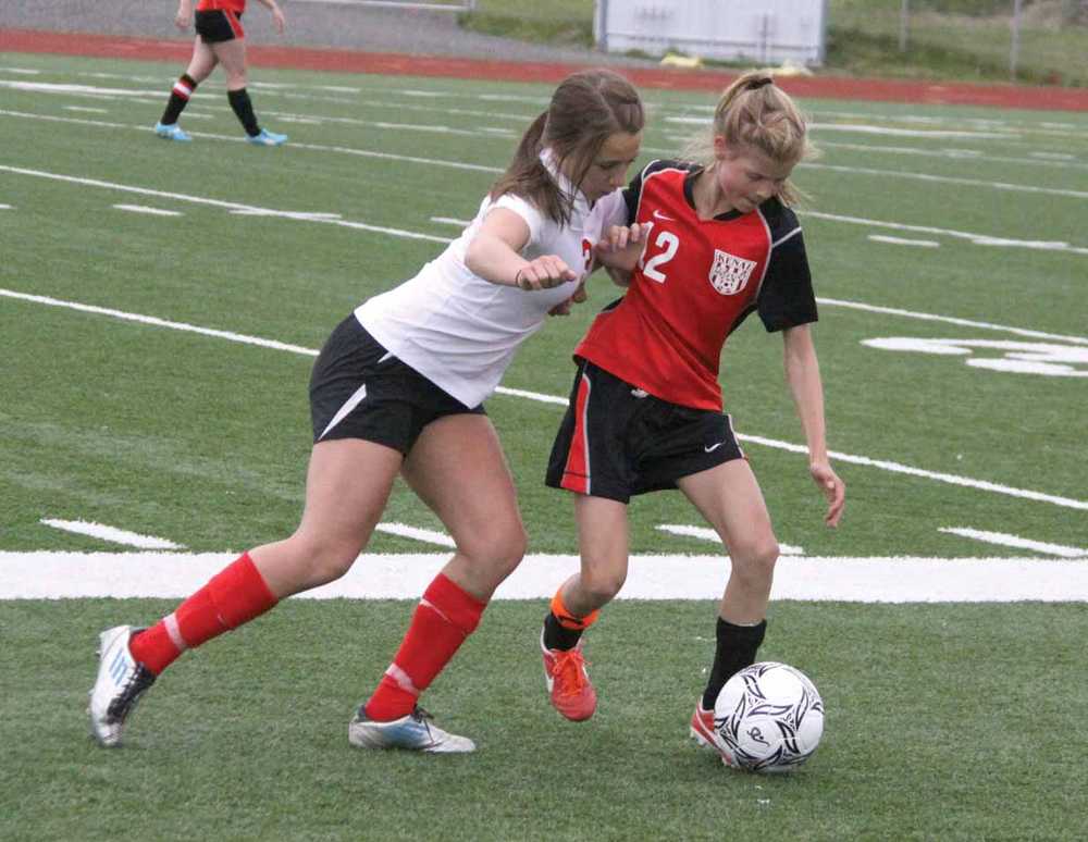 Wasilla freshman Ally Hull tries to push Kenai junior Allie Ostrander off the ball during Kenai's 2-0 win over the Warriors in the first round of the ASAA/First National Bank State Soccer Championships in Eagle River May 30.
