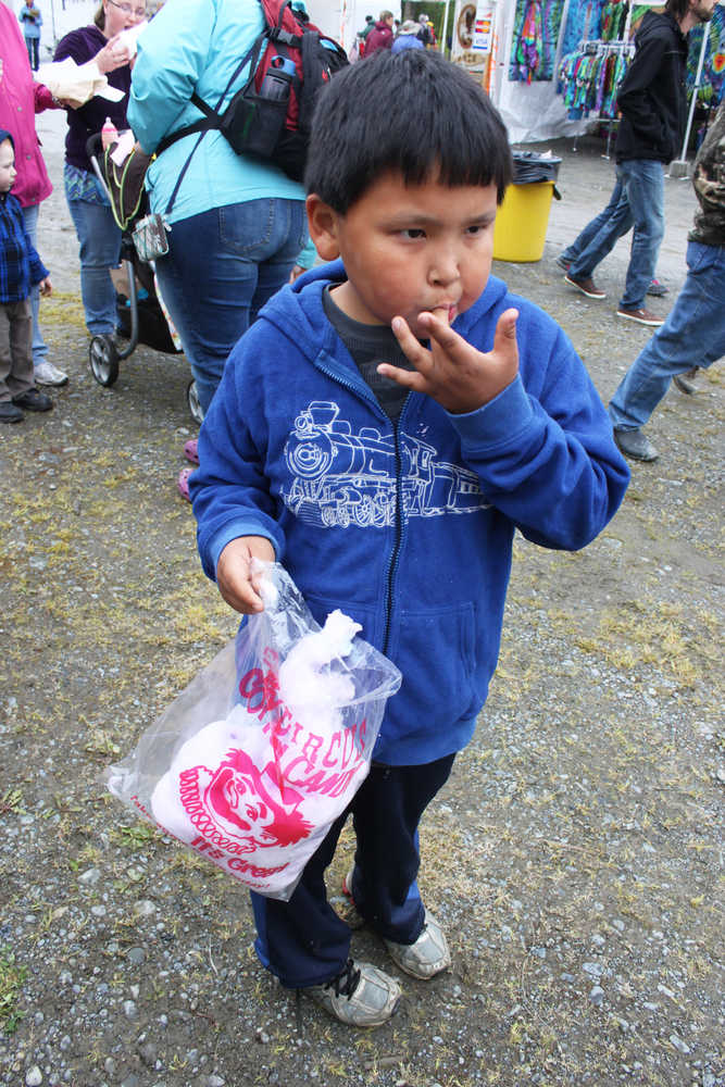 Photo by Kelly Sullivan/Peninsula Clarion Jacob Wohlers enjoys a long awaited cotton candy bag at the 24th annual Kenai River Festival, June 7, at Centennial Park.