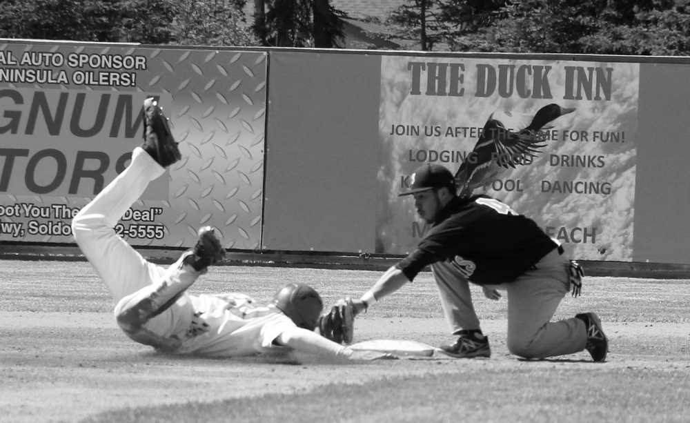 Photo by Dan Balmer/Peninsula Clarion Peninsula Oilers baserunner Jeff Paschke slides into second base late as the San Francisco infielder tags him out in the second inning Sunday at Coral Seymour Memorial Park in Kenai. The Oilers scored eight runs in the fifth inning and won their season opener 9-0.