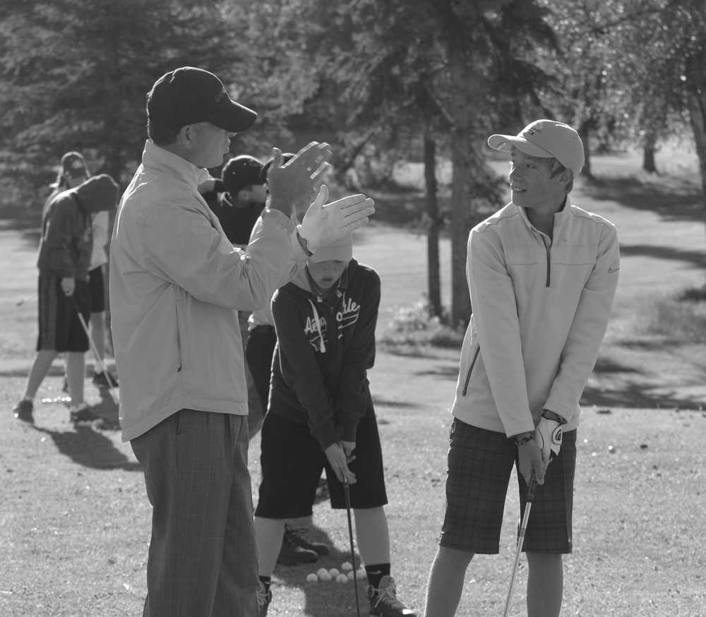Photo by Dan Balmer/Peninsula Clarion PGA Tour professional Charles "Chip" Beck helps Hudson Jackson, 12, from Nikiski with his swing at a junior golf camp Wednesday at the Birch Ridge Golf Course in Soldotna. Hudson, who has golfed for five years, was one of 39 kids who signed up to learn from Beck.