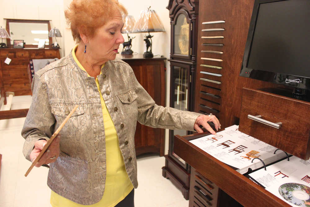 Photo by Kelly Sullivan/Peninsula Clarion Dee Cassel points out the different options customers have with the custom made Amish Furniture, which is made entirely without electricity, Wednesday, June 11, at Home Gallery in Kenai.