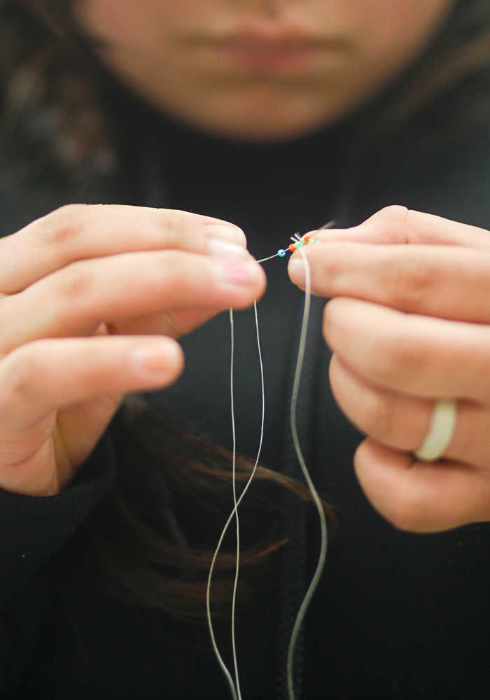 Photo by Rashah McChesney/Peninsula Clarion  Yvonne Waskey, 19, works on a beaded keychain for the Kenaitze Indian Tribe Tuesday April 15, 2014 at the Kenai Peninsula College, Kenai River Campus in Soldotna, Alaska. The crafting class is part of a "Native Creations & Reflections" series hosted by the college.