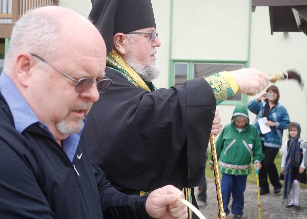 Photo by Rashah McChesney/Peninsula Clarion  Mike McBride holds a container of holy water for Bishop David Mahaffey during the bishop's blessing of a new outbuilding at the Holy Assumption of the Virgin Mary Russian Orthodox Church Thursday June 12, 2014 in Kenai, Alaska.