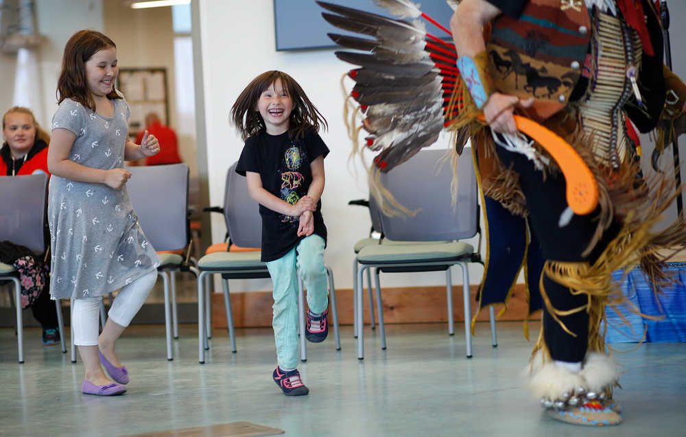 Photo by Rashah McChesney/Peninsula Clarion Cadence Fischer, 8, laughs as her younger sister Isis Fischer, 6, reacts to being allowed to dance during the grand opening ceremony for the Dena'ina Wellness Center Friday June 13, 2014 in Kenai, Alaska.