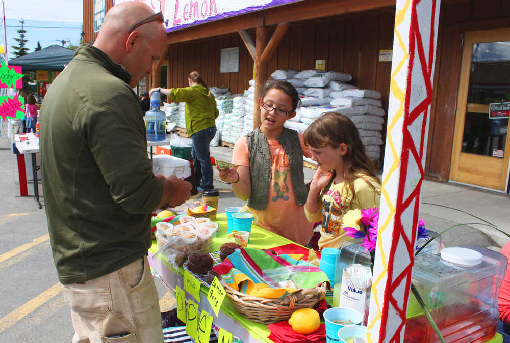 Photo by Kelly Sullivan/ Peninsula Clarion Lia Benner and Ava Grossl make a transaction at their lemonade stand, Saturday, June 14, in Soldotna.