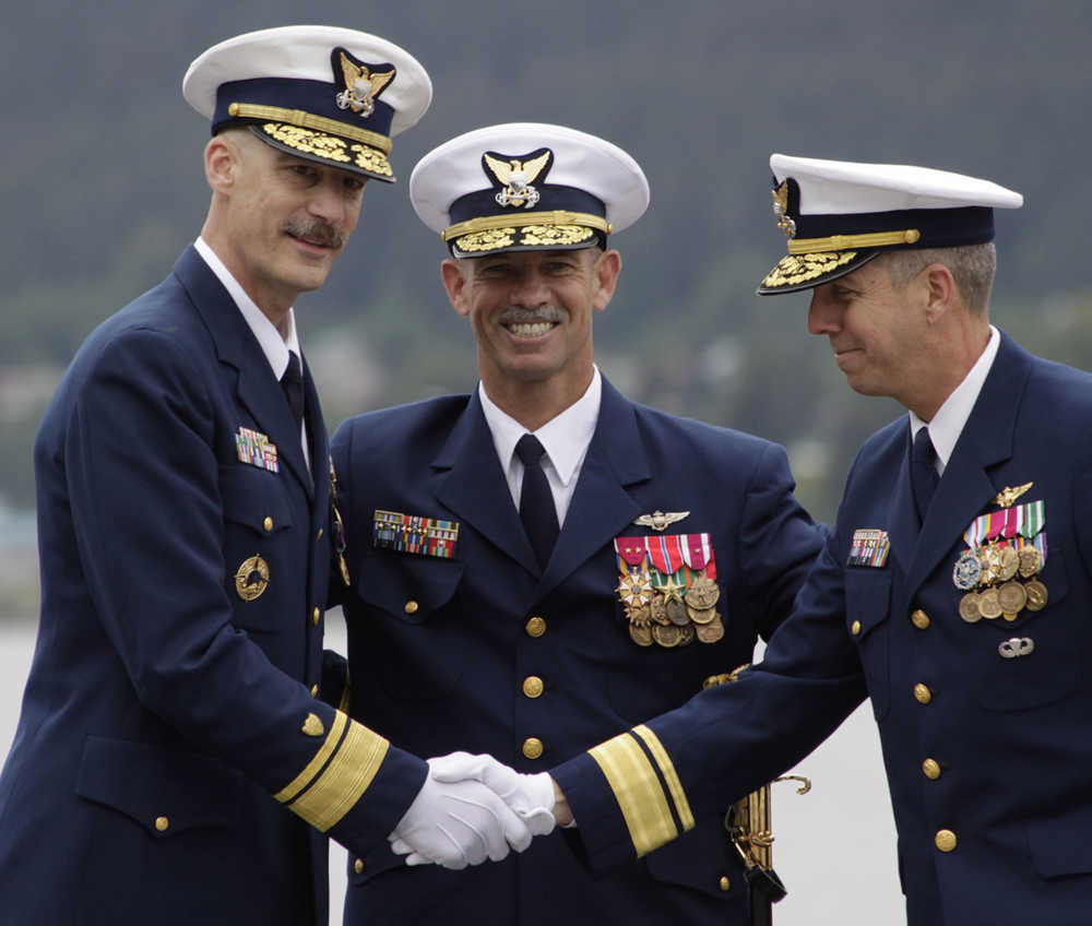 Coast Guard Rear Adm. Thomas Ostebo, left, shakes the hand of Rear Adm. Daniel Abel as Ostebo hands command of Coast Guard forces in Alaska to Abel on Thursday, June 12, 2014. Ostebo, nominated for promotion to vice admiral, has been assigned to a position in Washington, D.C. and will be leaving Alaska after three years in the state. Standing behind the two men is Vice Admiral Charles Ray, commander of the Coast Guard Pacific Area. (AP Photo/James Brooks, Capital City Weekly)