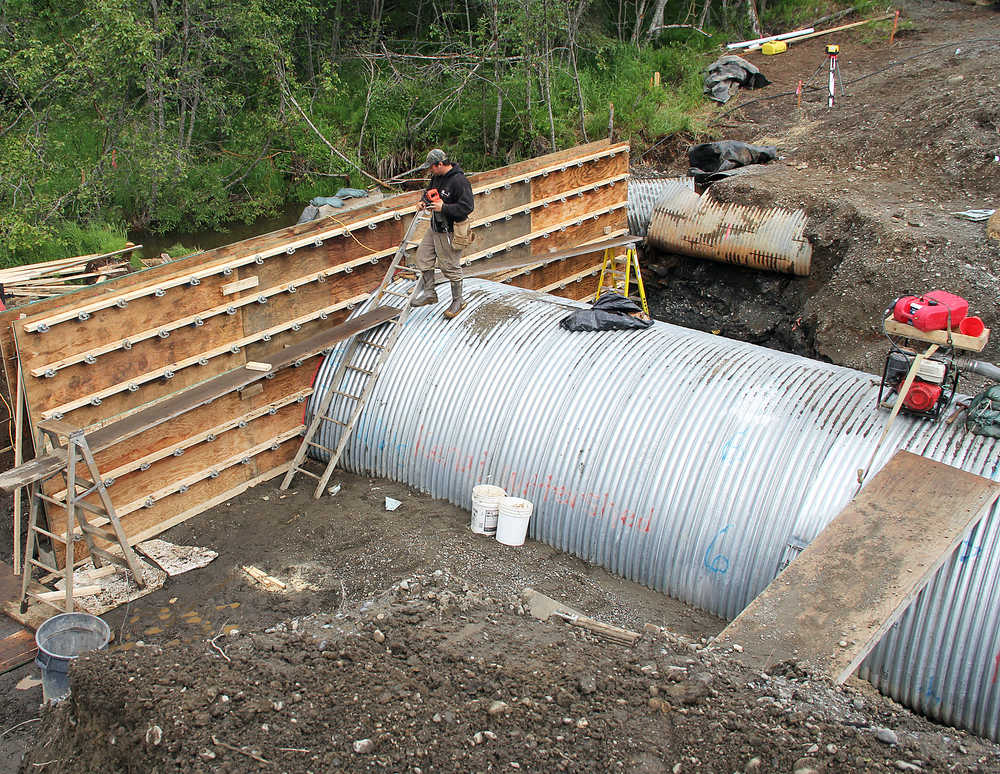 Photo by Dan Balmer/Peninsula Clarion An employee with Endries Company stands on a new culvert being installed beneath Beaver Loop Road Monday. The Kenai Watershed Forum is overseeing the project that will allow juvenile fish to migrate from Beaver Creek to the Kenai River. Groundwater has delayed the completion of the project for three more weeks but expected to be done the second week in July. A section of the road has been closed, cutting residents off from the Kenai Spur Highway intersection.