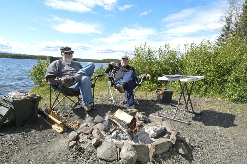 Photo by Rashah McChesney/Peninsula Clarion  Jon Preston and Norvell Robertson relax by Peterson Lake in the Kenai National Wildlife Refuge Wednesday June 18, 2014 near mile 68.3 of the Sterling Highway. Preston had been fishing for rainbow trout earlier in the day but said it was too windy to be successful.