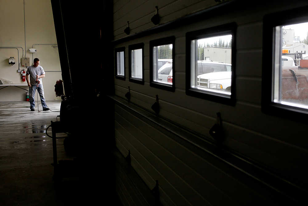 Photo by Rashah McChesney/Peninsula Clarion Nathanael Mole and Kia Youngren put the finishing touches on a mural they designed for the City of Kenai as their senior year project at Kenai Central High School Wednesday June 18, 2014 in Kenai, Alaska. The mural, which features a fire truck, dump truck and snow plow, will be hung in the city's new shop.