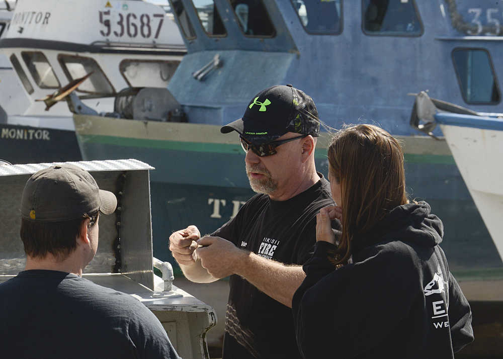 Photo by Rashah McChesney/Peninsula Clarion Dan Smith, left, and his wife Jessica Smith, listen to their captain for the season, Gail White, as the three prepare White's boat "Sonny Boy" to be put into the water at the Snug Harbor Seafoods receiving dock Thursday June 19, 2014 in Kenai, Alaska.