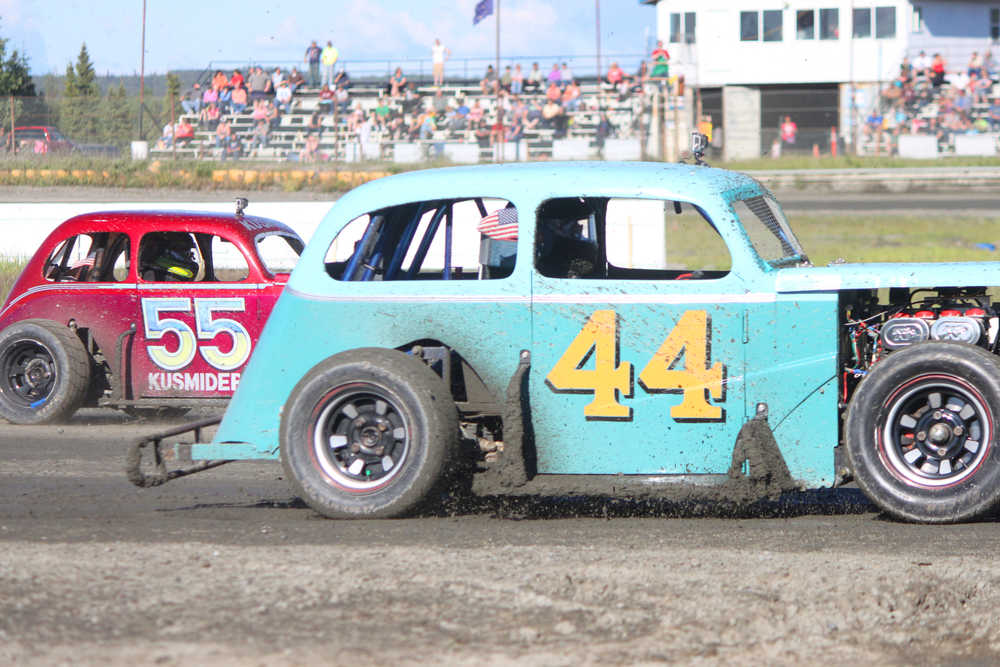 Photo by Kelly Sullivan/ Peninsula Clarion Legend car racers Tye Torkelson in car number 44, and David Kusmider in car number 55 are neck and neck during their race, Saturday, June 28, at Twin City Raceway.