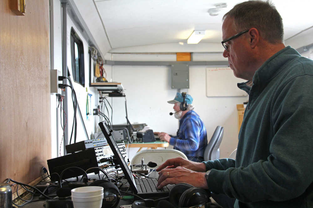 John Pfeifer, a ham radio operator, works to reach 300 connections in 24 hours on one station communicating through Morse code. In the background George Van Lone, who has been a ham since 1993, tries to verbally connect with other hams across the nation. The two are members of the Moosehorn Amateur Radio Club, which set up its trailer and mobile equipment and participated in the American Radio Relay League's Field Day on Saturday and Sunday at Skyview High School. Photo by Kaylee Osowski/Peninsula Clarion