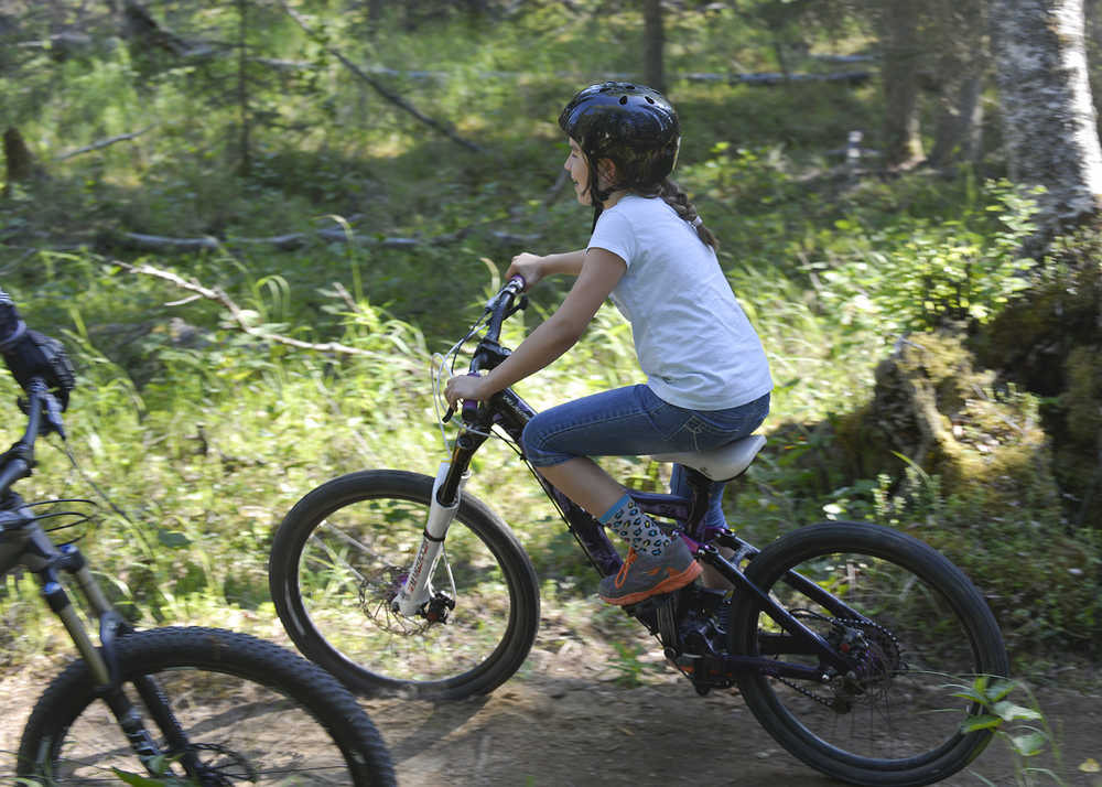 Photo by Rashah McChesney/Peninsula Clarion Lexi Larson eases her way down a banked turn on the new Moosequito Trail singletrack mountain biking trail Wednesday July 2, 2014 at the Tsalteshi Trails in Soldotna, Alaska.