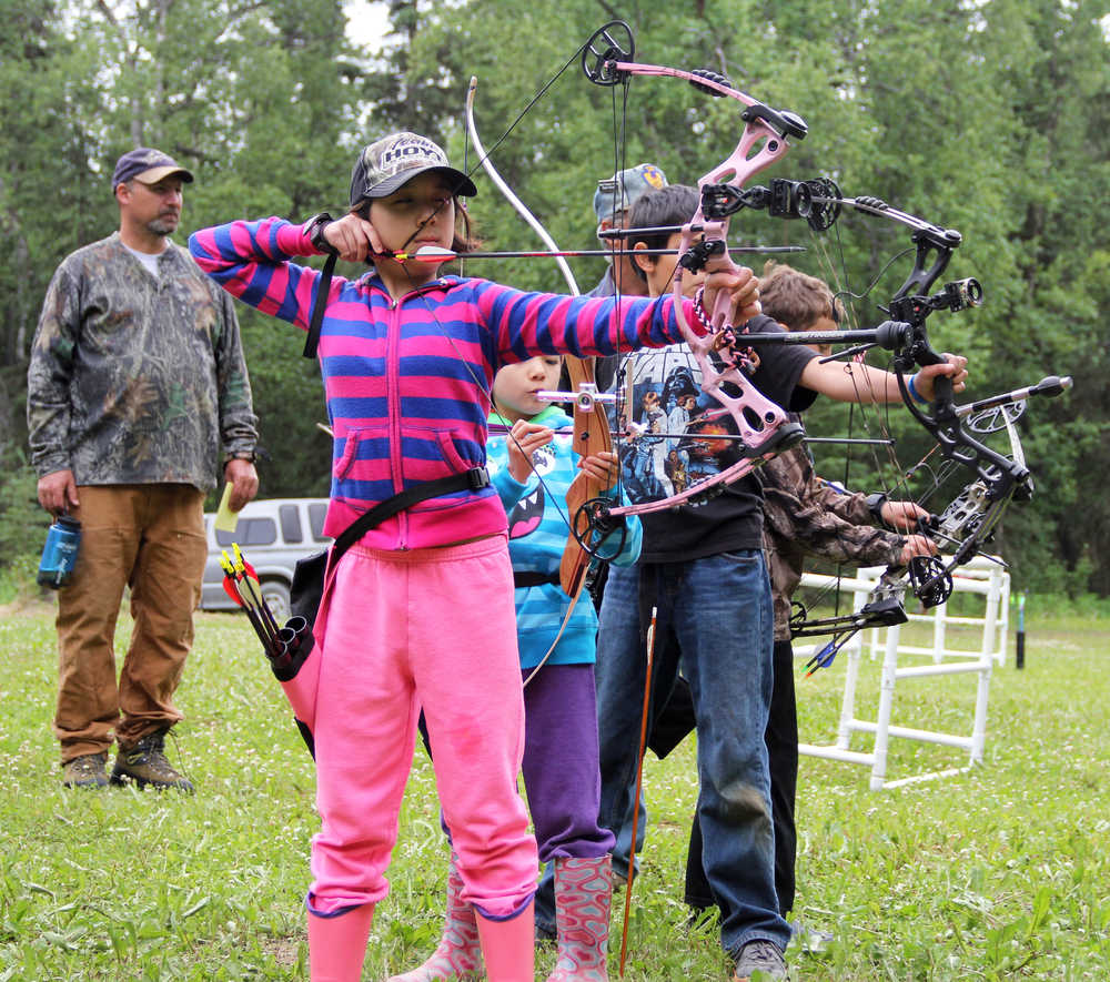 Photo by Dan Balmer/Peninsula Clarion Kira (front) and Lena Cook from Palmer try to be the first to hit an apple with their arrow during an archery shooting tournament at the Kenai Peninsula Archery Range Sunday in Soldotna. Kira placed second in the feamle cubs freestyle division.