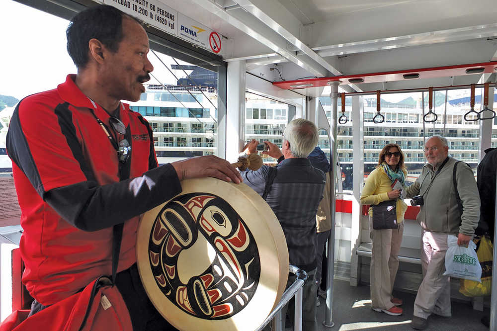 John Perkins, pictured with his drum, educates tourists on the uses of Sitka spruce trees, hemlock trees, and red alder trees, June 26, 2014. Perkins is a Goldbelt Mount Roberts Tram conductor. (AP Photo/Capital City Weekly, Mary Catharine Martin)