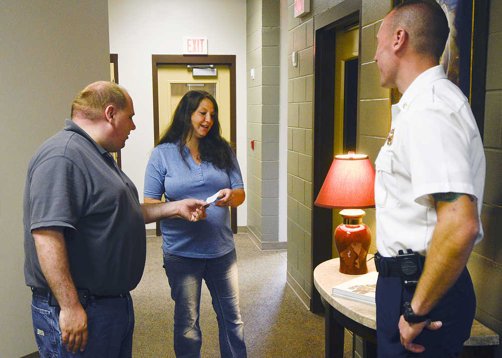 Photo by Rashah McChesney/Peninsula Clarion Dan Nelson, Daniell Stynsberg, and Brad Nelson met Monday July 7, 2014 as Stynsberg presented the two with a check for $2500 in proceeds from a t-shirt commemorating the Funny River Horse Trail Wildfire fighting efforts  at the Central Emergency Services administration building in Soldotna.