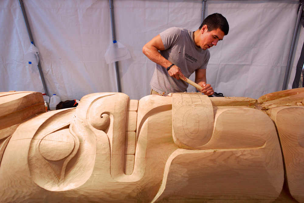 Haida carver TJ Young works on a bear holding its tongue on the Eagle totem pole for the Gajaa Hít building on Thursday. TJ and his brother, Joe, have been working on two poles and a screen to replace the aging ones in front of the building. The project has been organized through Sealaska Heritage Institute in conjunction with the Tlingit Haida Regional Housing Authority, who owns the building.
