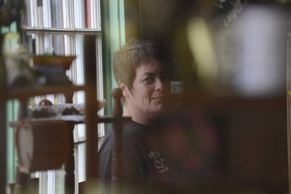 Photo by Rashah McChesney/Peninsula Clarion  Rondell Gonzalez, owner of Pye Wackets, a metaphysical supplies and gift shop, smiles as she looks at her reflection Tuesday July 9, 2014 in Soldotna, Alaska.